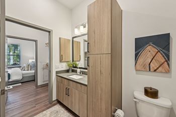 A bathroom with a wooden vanity and a toilet at The Concord Luxury Apartments, Sarasota 34240